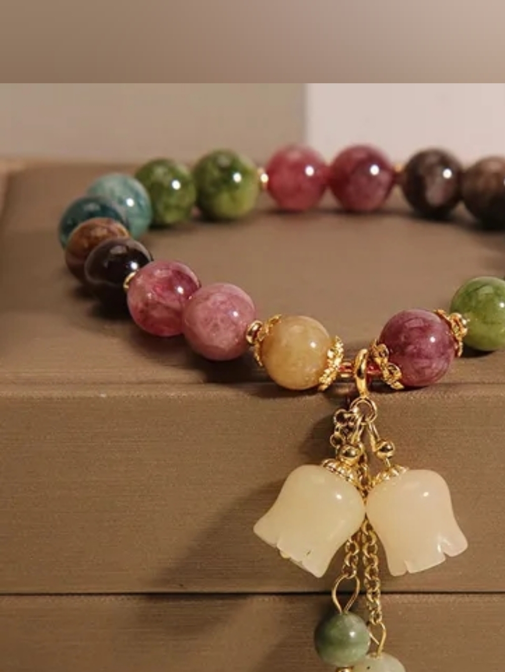 Multicolor Gemstone Beaded Bracelet with Gold Tassel and Cream Flower Charms